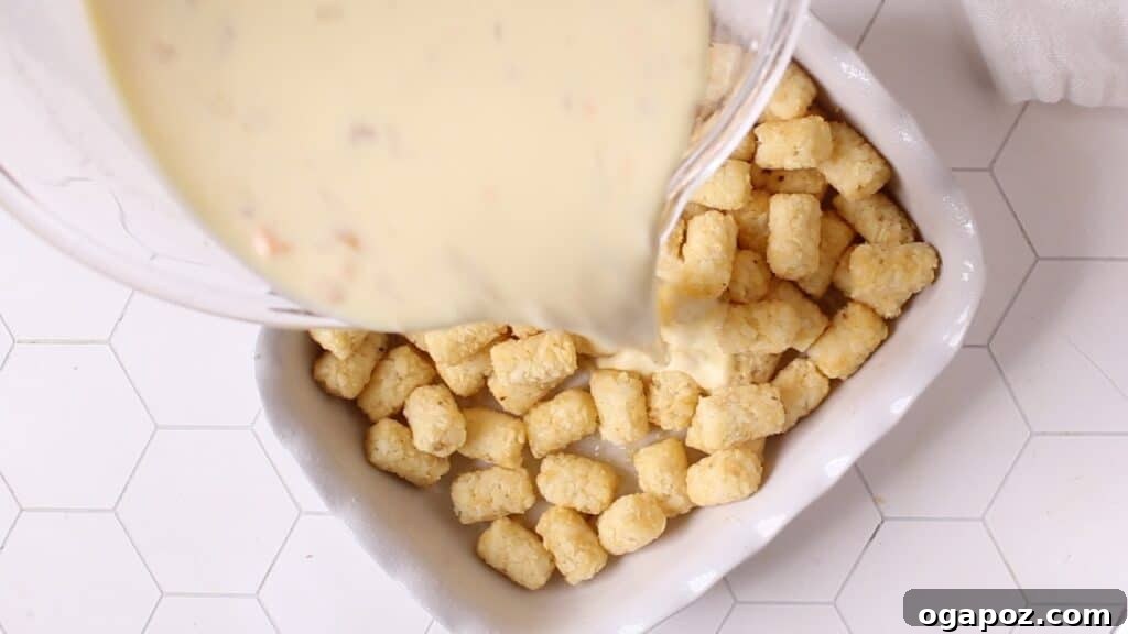Golden Tater Tot Morning Bake 4 Pouring the egg mixture over the tater tots in a baking dish.