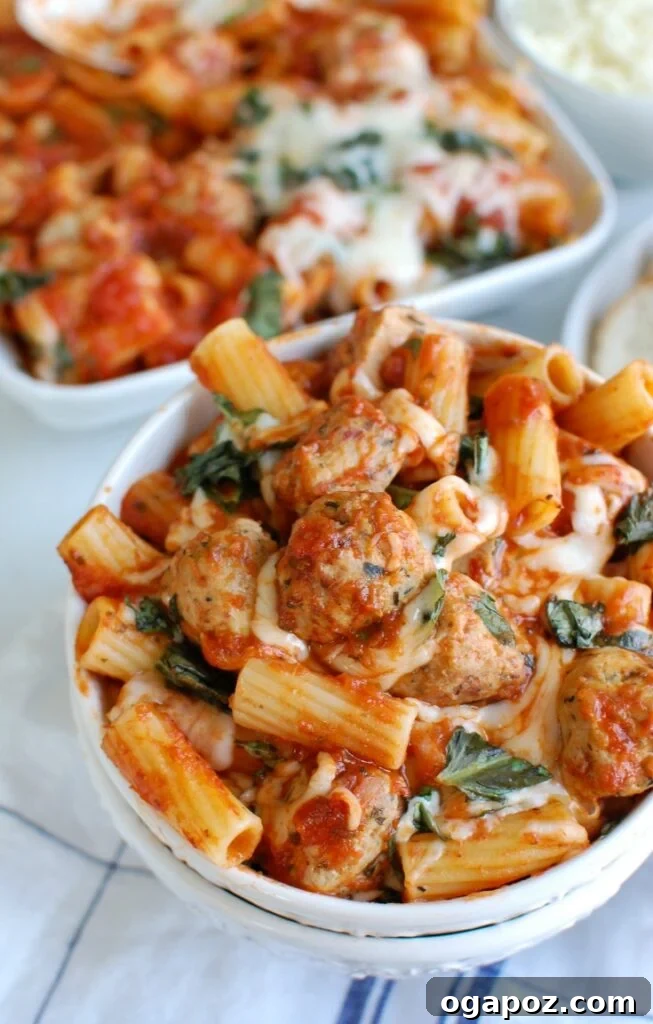 Comforting Baked Rigatoni with Tender Chicken Meatballs 4 A large baking dish filled with Easy Baked Rigatoni with Chicken Meatballs, garnished with fresh basil.