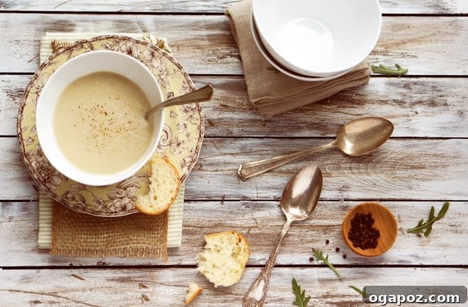 Velvety Apple Parsnip Delight 2 A bowl of creamy apple parsnip soup garnished with fresh herbs.