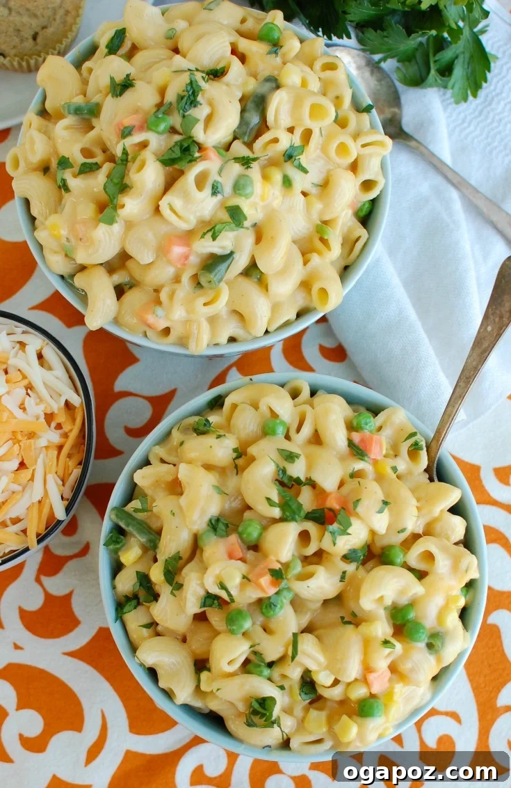 Two bowls of Instant Pot Vegetable Mac and Cheese, garnished and ready to serve.
