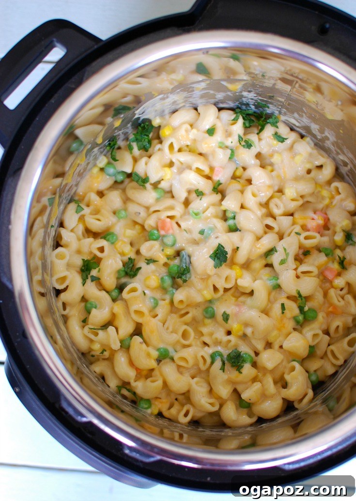 Instant Pot filled with creamy macaroni and cheese, showing the cooking process.