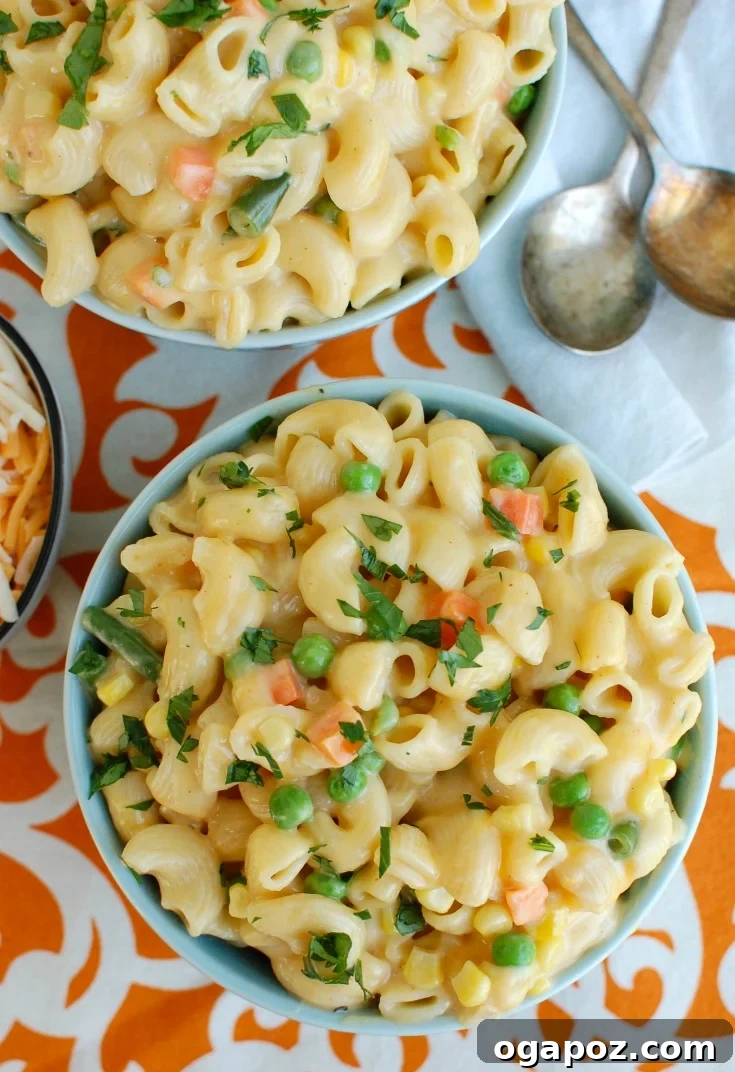 Close-up of Instant Pot Vegetable Mac and Cheese in a blue bowl, highlighting the creamy texture and vegetables.