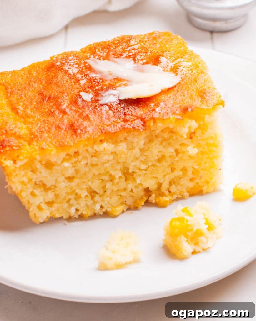Golden Cornbread Delight 2 A piece of Cornbread Casserole on a plate with butter.