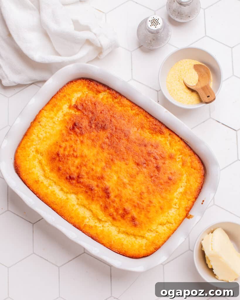 Golden Cornbread Delight 18 Cornbread casserole on the counter with cornmeal and butter beside it.