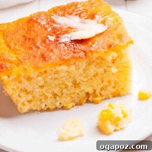 A piece of Cornbread Casserole on a plate with butter.