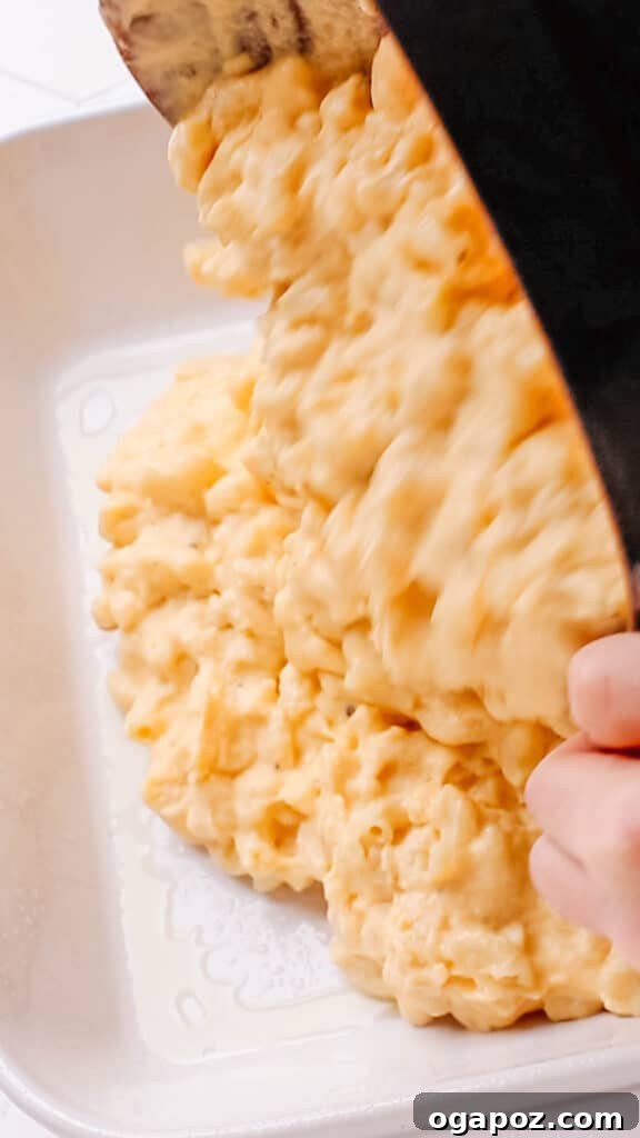 Classic Velvety Baked Macaroni and Cheese 14 Transferring the macaroni and cheese mixture from a pot into a greased casserole dish.