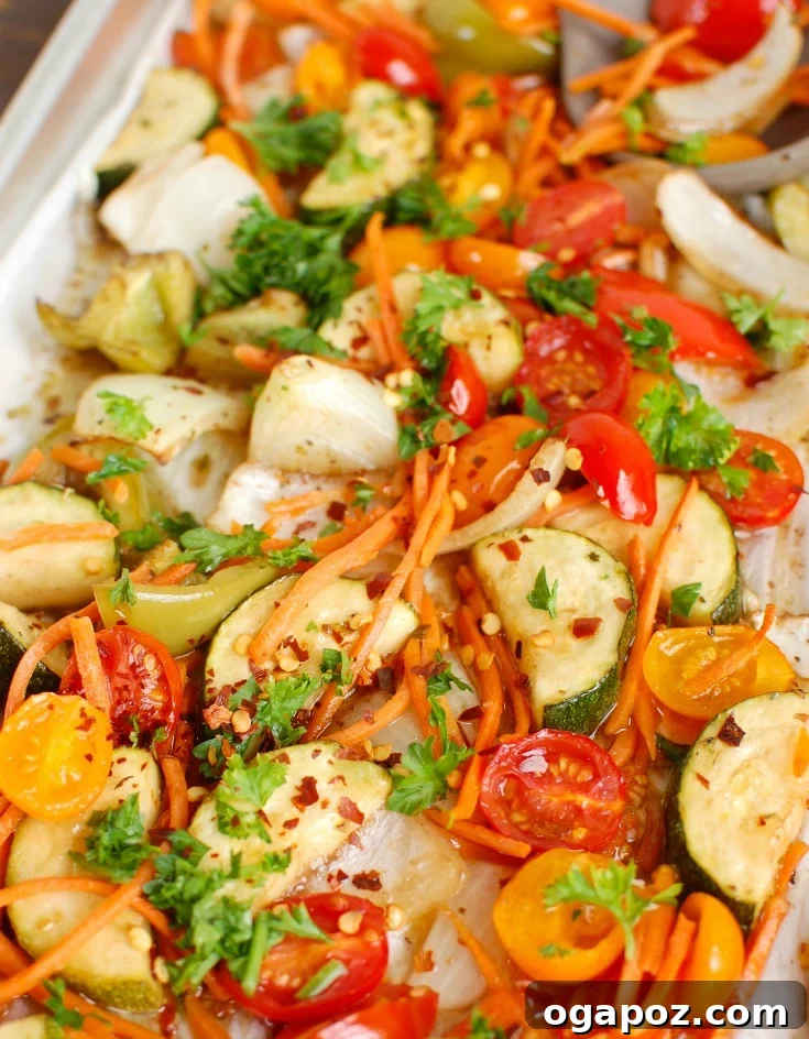 Sticky Balsamic Chicken & Roasted Veggies 5 A mix of roasted vegetables and chicken tenderloins on a sheet pan, ready to be served.