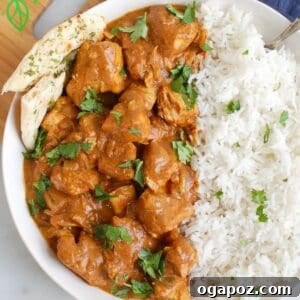 Slow Cooker Butter Chicken in a serving bowl with rice and naan