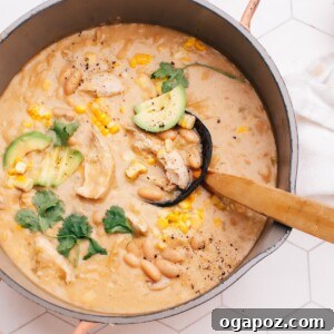 Creamy white chicken chili in a dutch oven, garnished and ready to be served.