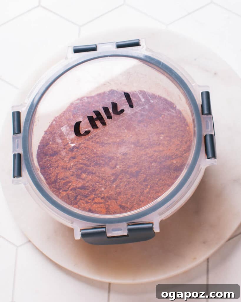 Secret Chili Seasoning Recipe 8 A tightly sealed glass container filled with homemade chili powder, showcasing its rich red color, emphasizing freshness and proper storage.