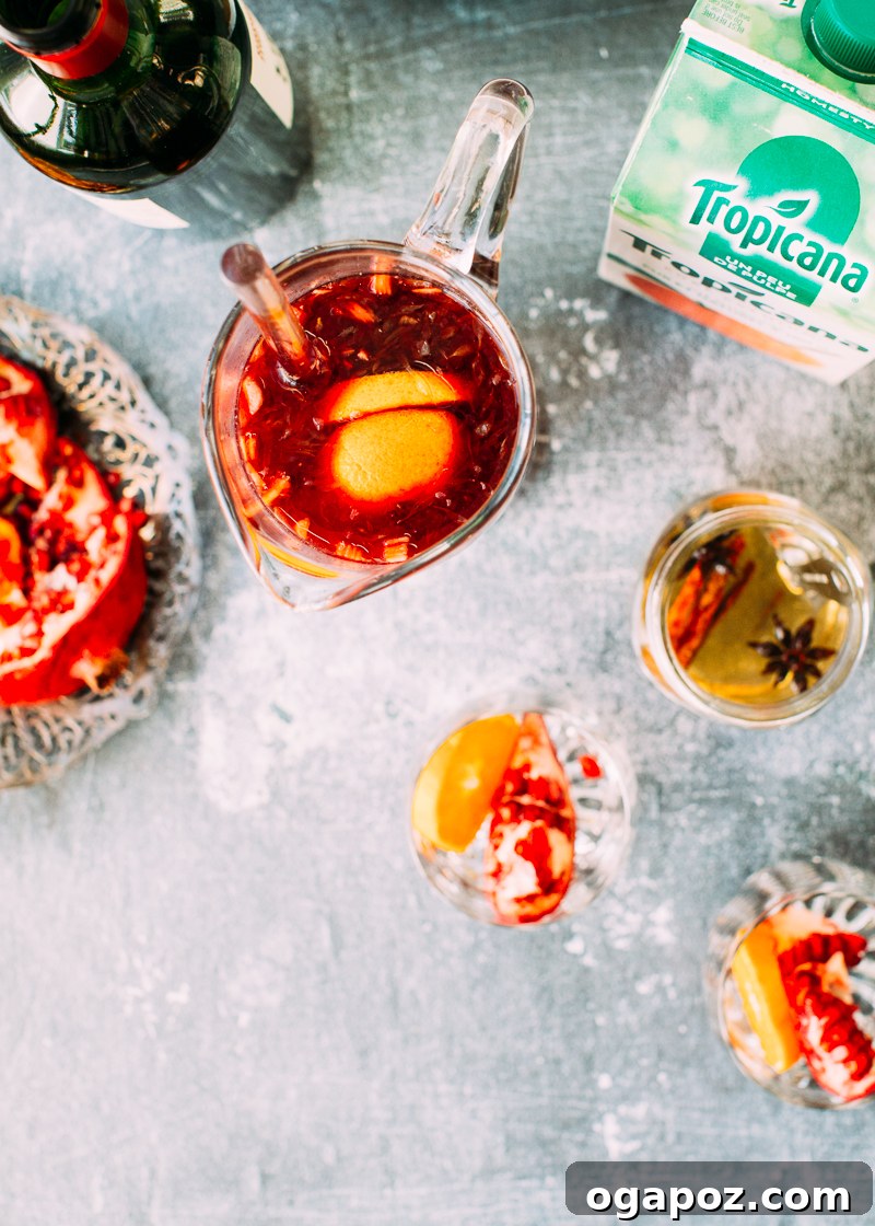 Close-up of Christmas Sangria in a glass, showcasing fresh orange slices and pomegranate seeds.