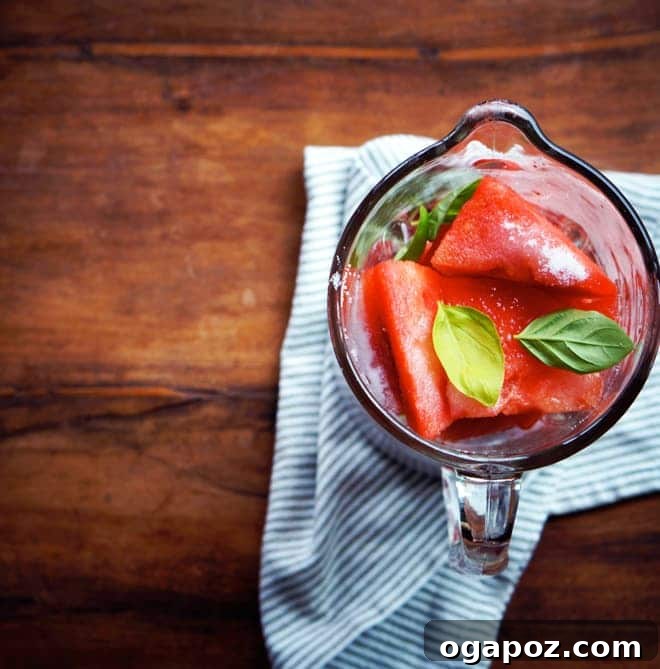 Spiked Melon Splash 3 Glasses of watermelon vodka cocktail on a tray with fresh basil.