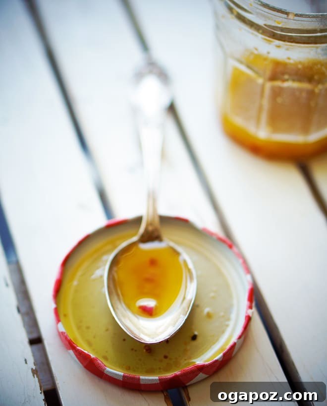 Everyday Essential Vinaigrette 4 A freshly dressed green salad in a white bowl, showing lightly coated leaves.
