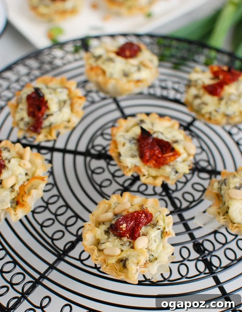 Savory Sun-Dried Tomato Spinach Artichoke Phyllo Bites 3 Freshly baked Spinach Artichoke Sun-dried Tomato Phyllo Bites cooling on a wire rack.