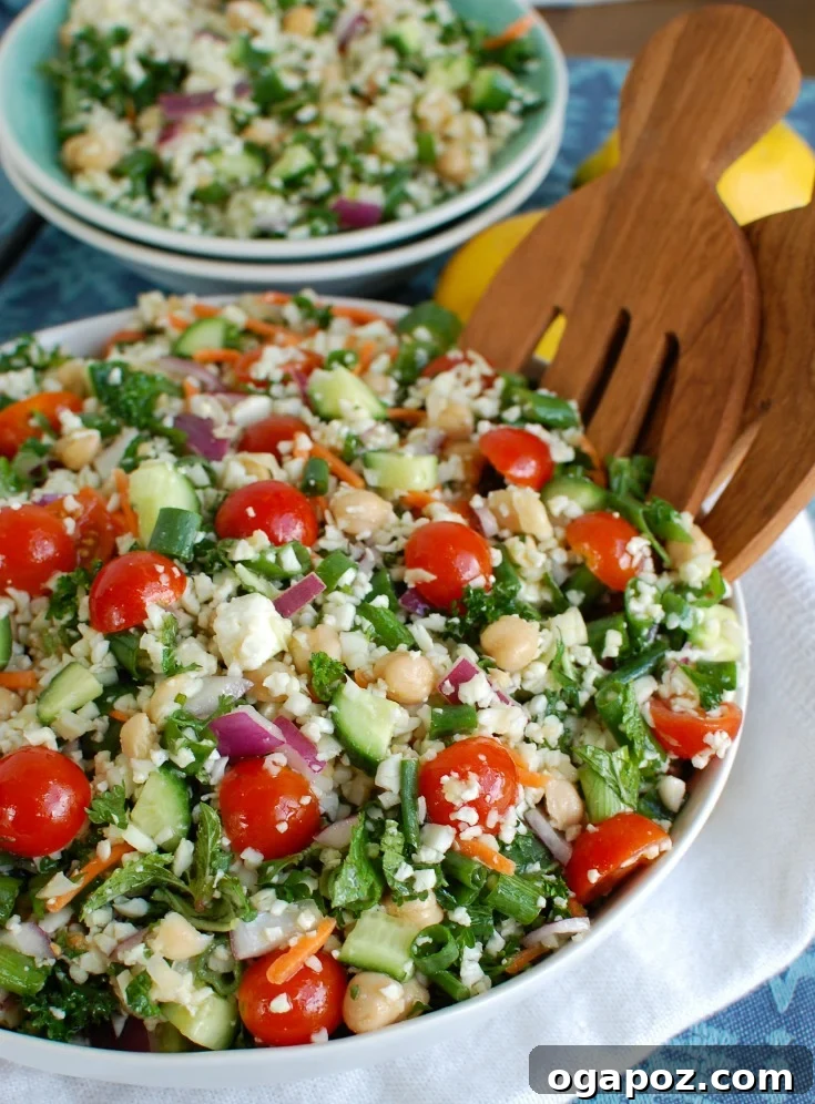 A vibrant Mediterranean Chickpea Cauliflower Salad served in a large bowl, showcasing fresh ingredients like cherry tomatoes, cucumber, and feta.