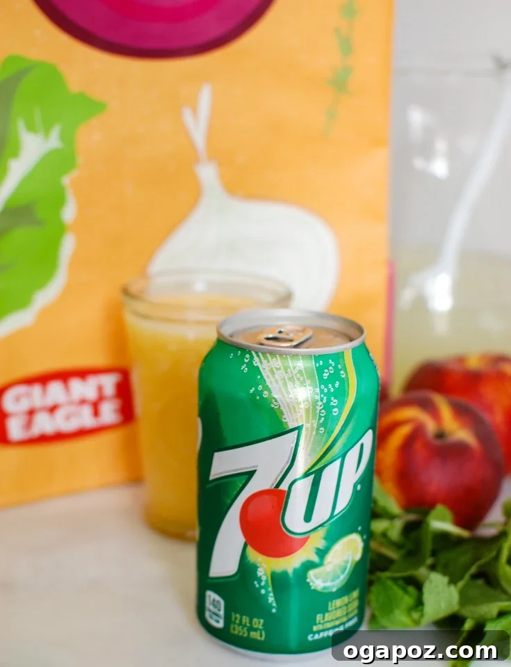 Peachy Fizz Lemonade 3 Ingredients laid out for Sparkling Peach Lemonade, including peaches, lemonade, 7UP, and mint.