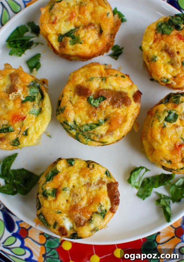 Southwest Turkey Sausage Sunrise Bites 4 Overhead view of several Southwestern Turkey Sausage Egg Cups arranged on a baking sheet, ready for serving