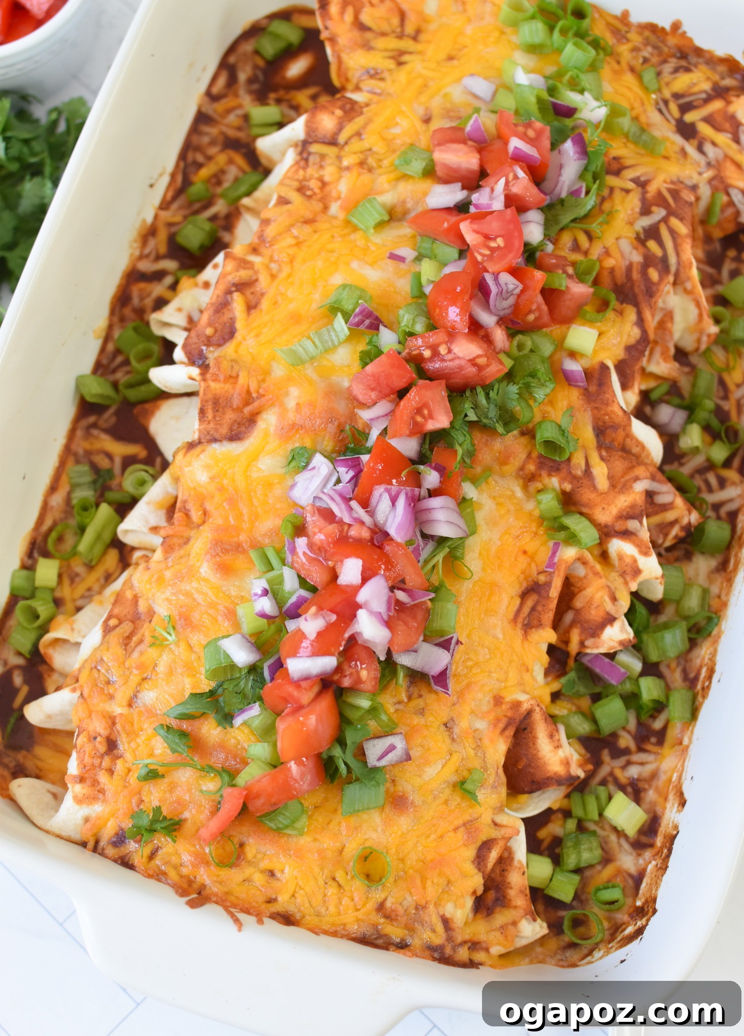 Quick & Hearty Beef Enchiladas 4 Plated Beef Enchiladas garnished with fresh cilantro and sour cream.