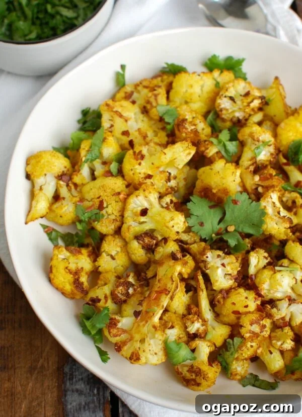 Golden Turmeric Roasted Cauliflower 4 Close-up of Turmeric Roasted Cauliflower garnished with fresh cilantro on a serving plate.