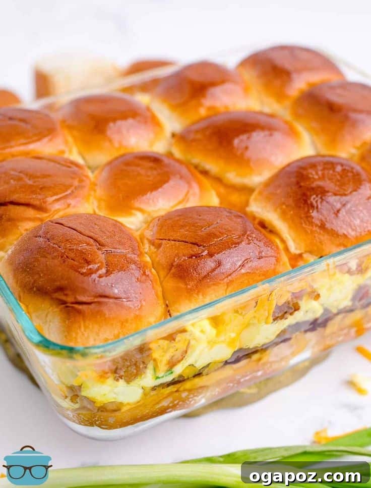 Golden-brown Sausage, Egg, and Cheese Breakfast Sliders, baked together in a casserole dish, topped with a glossy glaze and ready for sharing.
