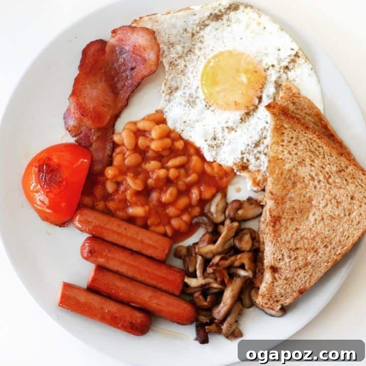 A generous English Breakfast spread, featuring sizzling sausages, fried eggs, baked beans, mushrooms, and toast, embodying a classic hearty start to the day.