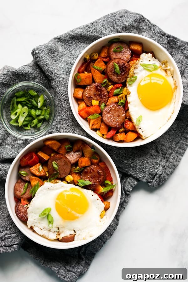 A wholesome bowl of Sweet Potato Breakfast Hash, featuring smoked sausage, sweet potatoes, corn, and colorful peppers, garnished with fresh herbs.