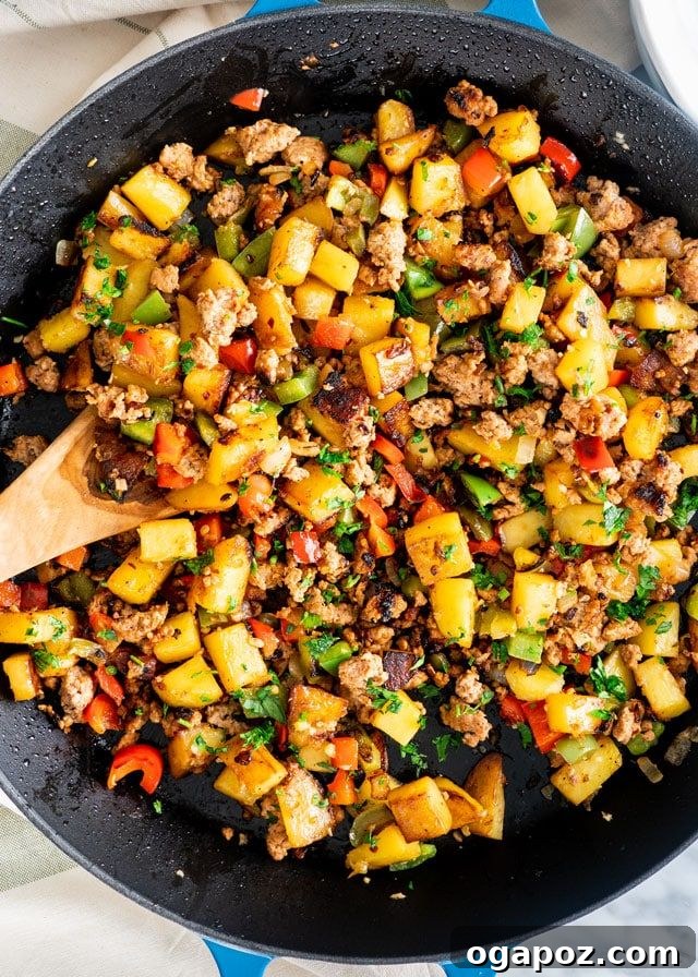 A vibrant Sausage Potato Hash, cooked in a skillet, showcasing colorful vegetables, savory sausage, and crispy potatoes for a complete breakfast.