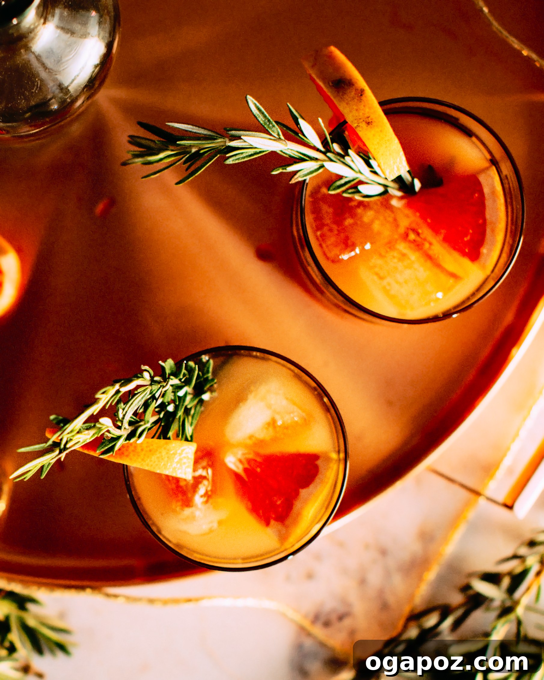 Zesty Rosemary Gin Spritz 3 An elegant copper barware set, including a polished tray and two glasses, displayed on a kitchen island with fresh fruit and foraged greenery, enhancing the festive atmosphere.
