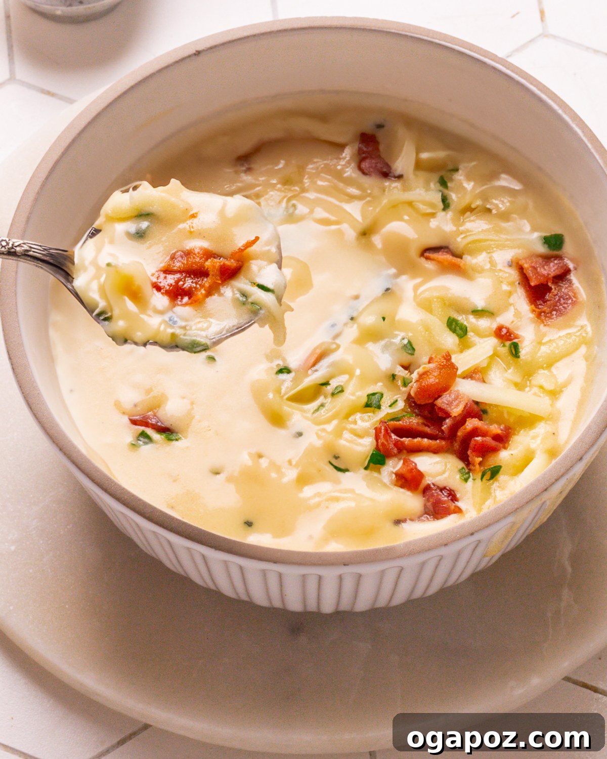 Quick Homestyle Potato Soup 2 A steaming, inviting bowl of creamy easy potato soup garnished with fresh green onions and a rustic spoon, ready to be enjoyed.