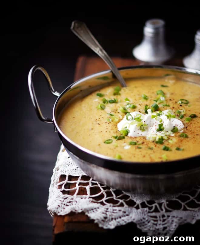 Quick Homestyle Potato Soup 4 Close-up of a rustic bowl of easy potato soup recipe with a dollop of sour cream and fresh green onions, showcasing its rich, creamy texture and inviting appeal.