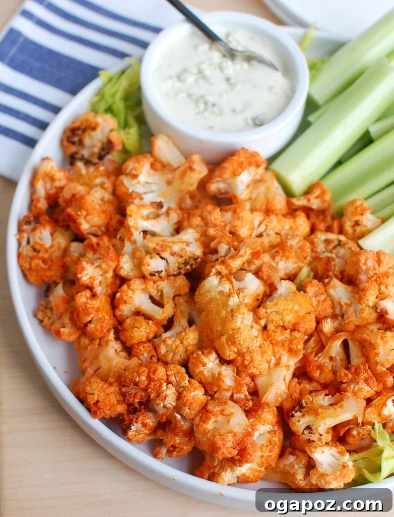 Buffalo Cauliflower Wings 2 Crispy Roasted Buffalo Cauliflower served on a white plate with blue cheese dipping sauce