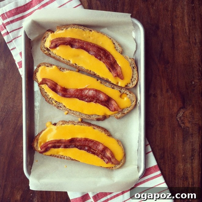 Bacon Cheese Bombs 3 A close-up of the bubbling, golden cheese sauce on bread, topped with crispy bacon, before broiling