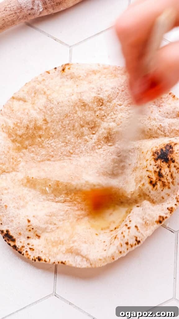 Pillowy Soft Roti A Time Tested Family Favorite 17 roti being brushed with butter.