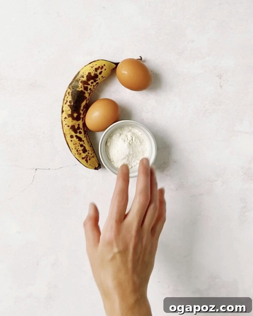 Wholesome Banana Bran Delights 3 A hand reaching for ripe bananas, flour, and eggs on a kitchen counter, ready for baking delicious banana bran muffins.