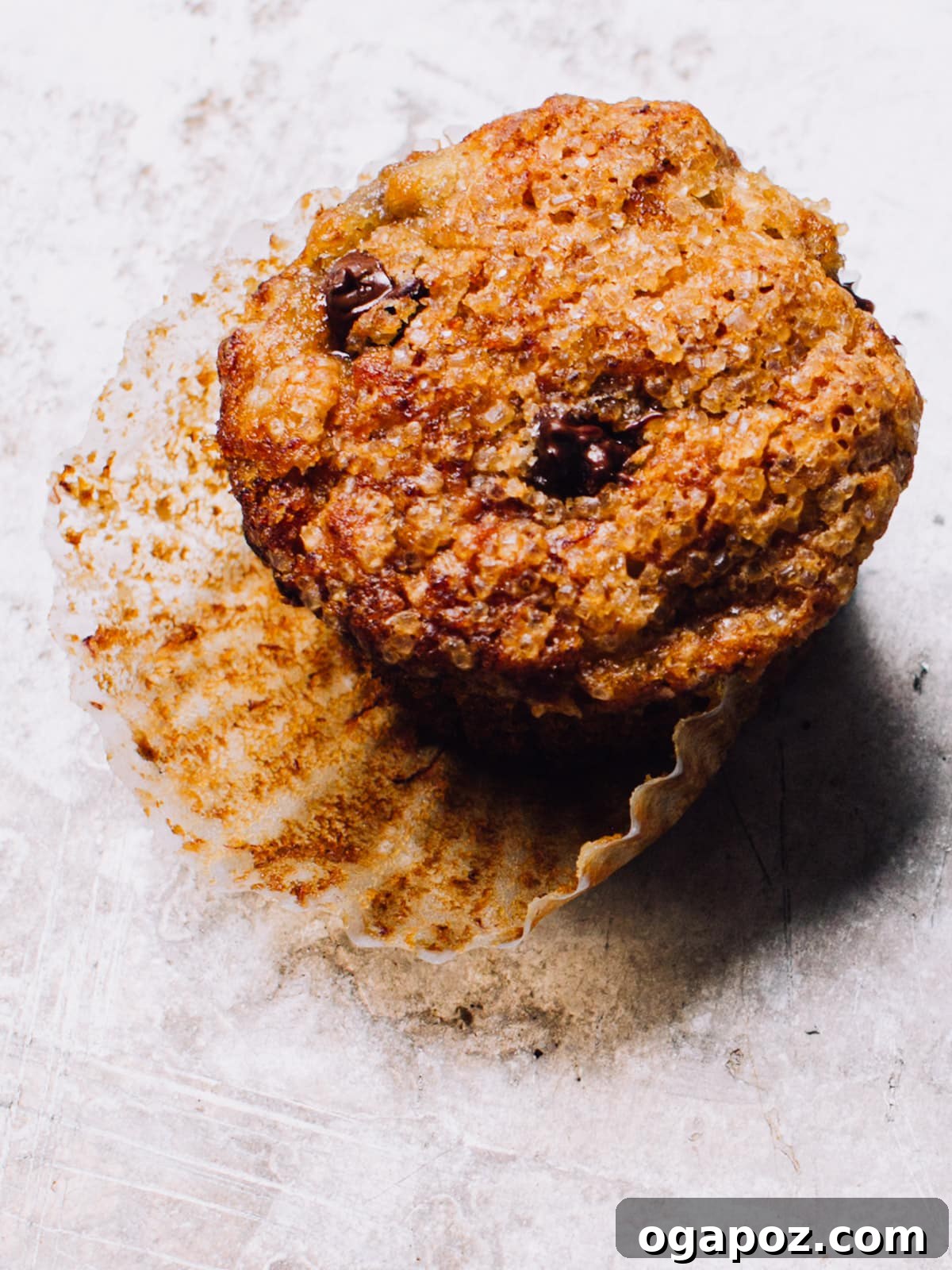 Wholesome Banana Bran Delights 5 A close-up shot of a freshly baked batch of banana bran muffins, some topped with banana slices, resting on a wire cooling rack. The muffins are golden brown, showcasing a perfect dome and inviting texture.