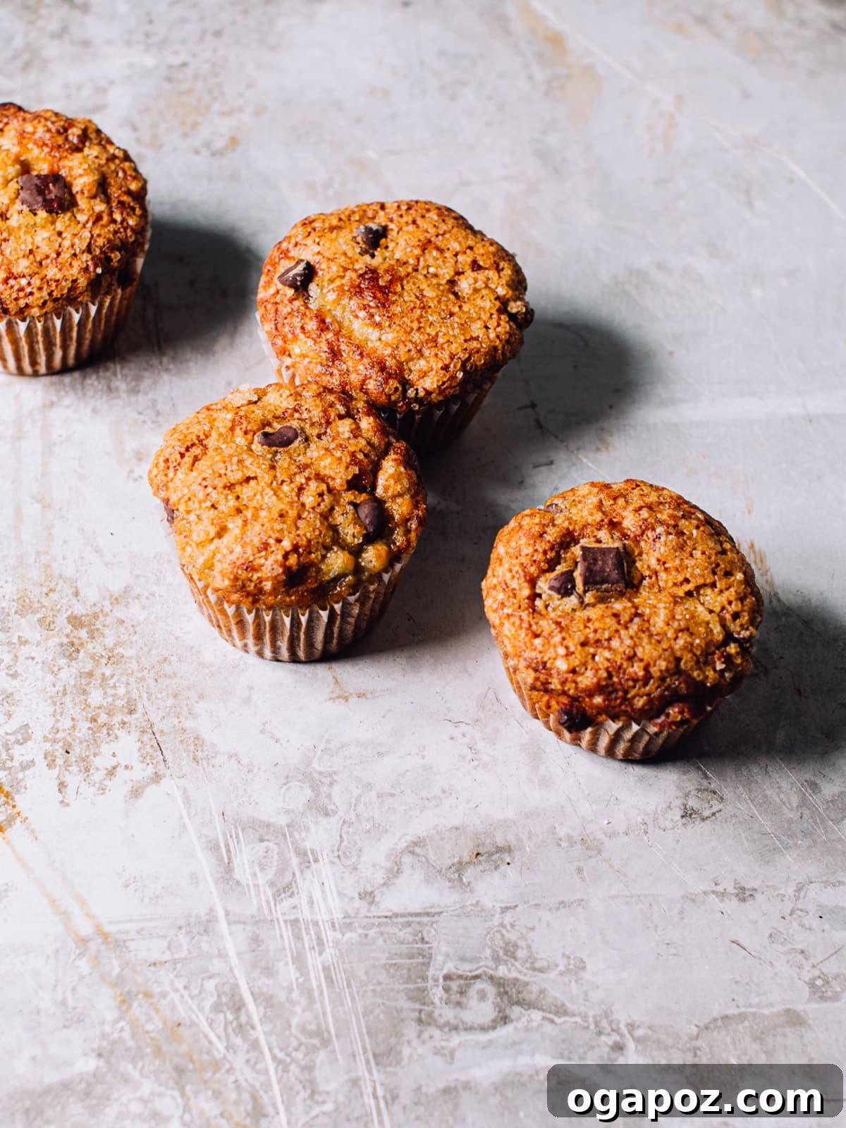 Wholesome Banana Bran Delights 7 A close-up shot of a baked banana bran muffin, showcasing its moist crumb and a few chocolate chips embedded within, sitting on a wire rack.