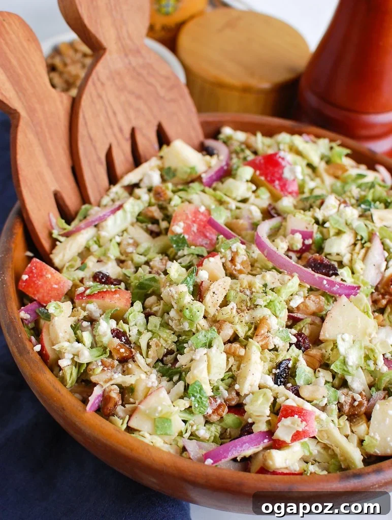 Harvest Brussels Salad with Apple & Chèvre 2 Brussels Sprout Apple Goat Cheese Salad served in a wooden bowl, highlighting its fresh ingredients and vibrant colors.