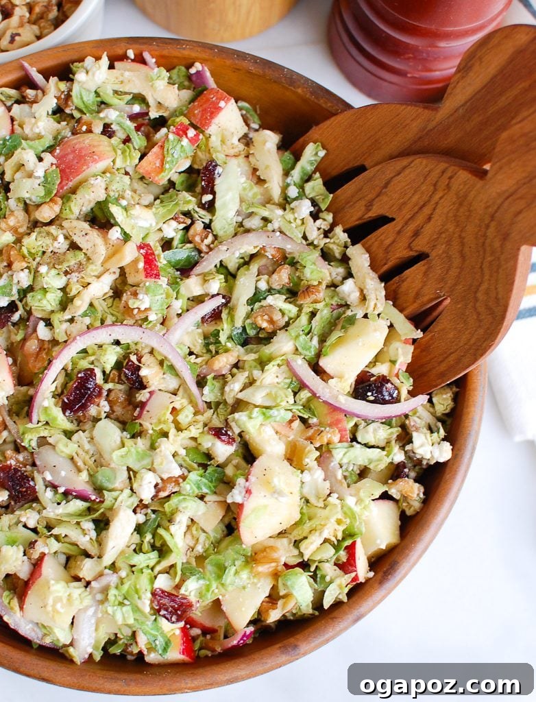 Harvest Brussels Salad with Apple & Chèvre 4 Brussels Sprout Apple Goat Cheese Salad being tossed with wooden tongs in a large bowl.
