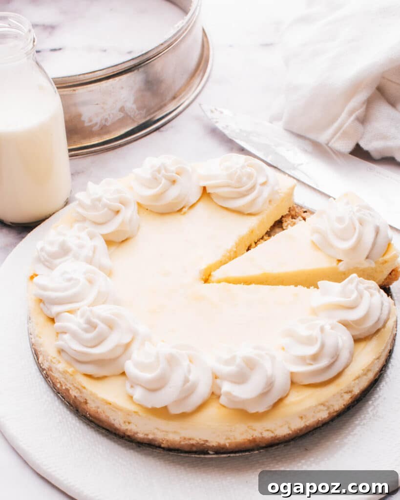 Philadelphia Cheesecake Classic Perfection Pro Insights 11 A freshly sliced Philadelphia cheesecake on a stand, with one perfect slice already removed.