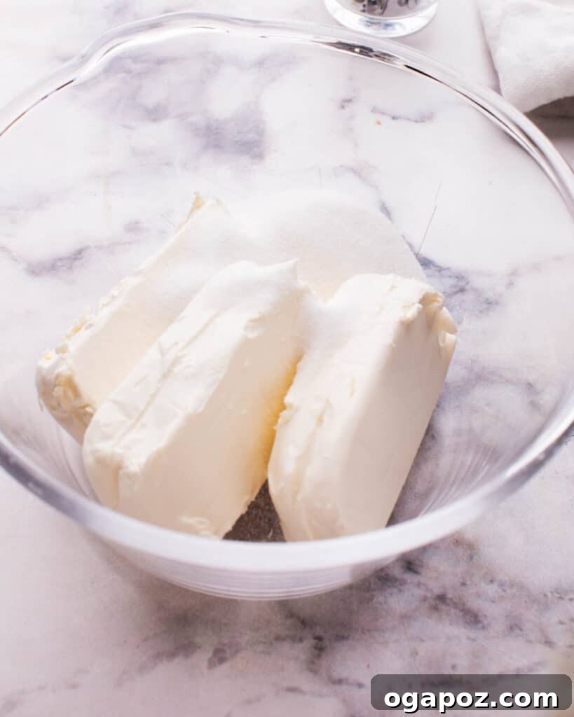 Philadelphia Cheesecake Classic Perfection Pro Insights 15 Softened blocks of cream cheese in a bowl, ready for mixing.