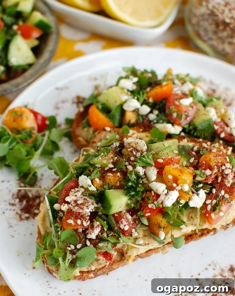 Hummus Toast on White Plate A finished Mediterranean Hummus Toast with Za'atar on a white plate, ready to be enjoyed.