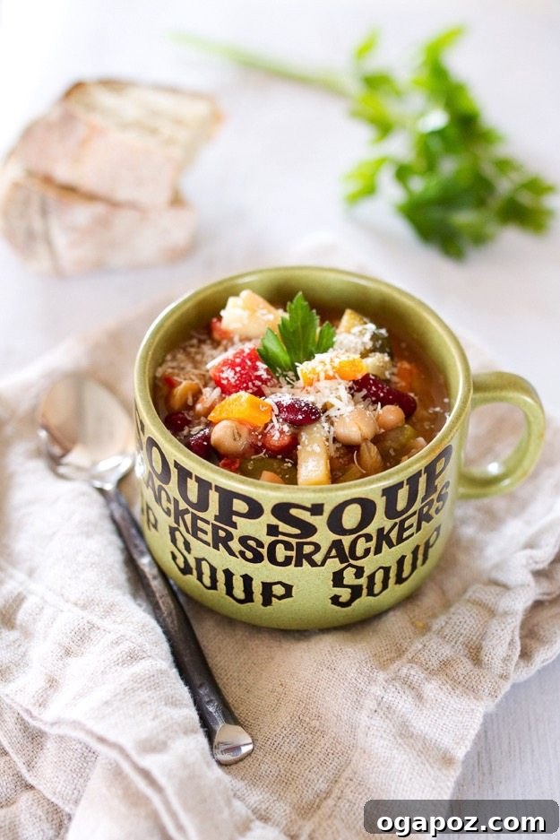 A steaming bowl of Slow Cooker Minestrone Soup, packed with colorful vegetables, beans, and pasta in a rich tomato broth, garnished with fresh parsley.