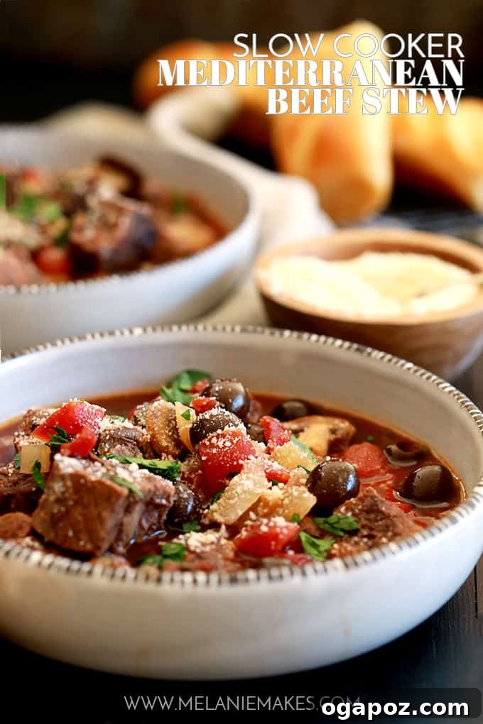 Hearty Slow Cooker Mediterranean Beef Stew, featuring tender beef, potatoes, carrots, and olives in a rich tomato-based sauce, garnished with fresh herbs.