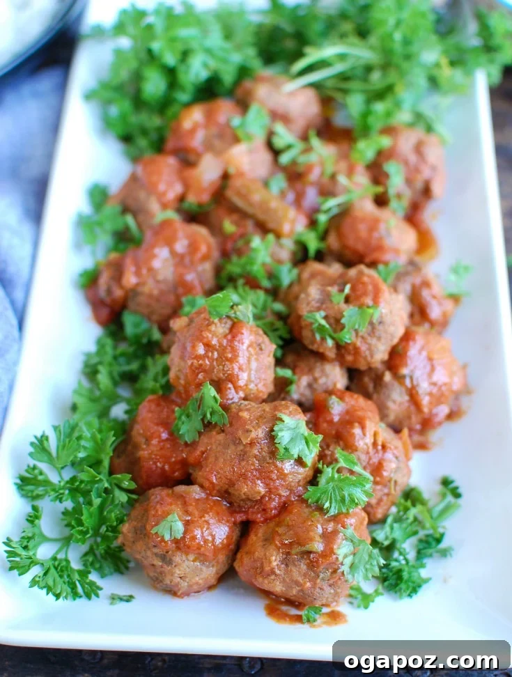 Tender Slow Cooker Mediterranean Beef Meatballs paired with Lebanese Green Beans in a rich tomato-based sauce, garnished with fresh parsley, served with rice.