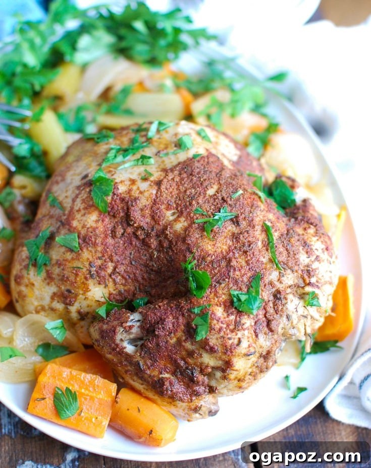 A perfectly cooked Slow Cooker Mediterranean Whole Chicken, golden brown and garnished with fresh herbs and lemon slices.