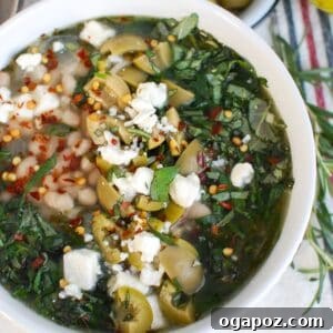Mediterranean White Bean Soup in a bowl, garnished with fresh herbs.