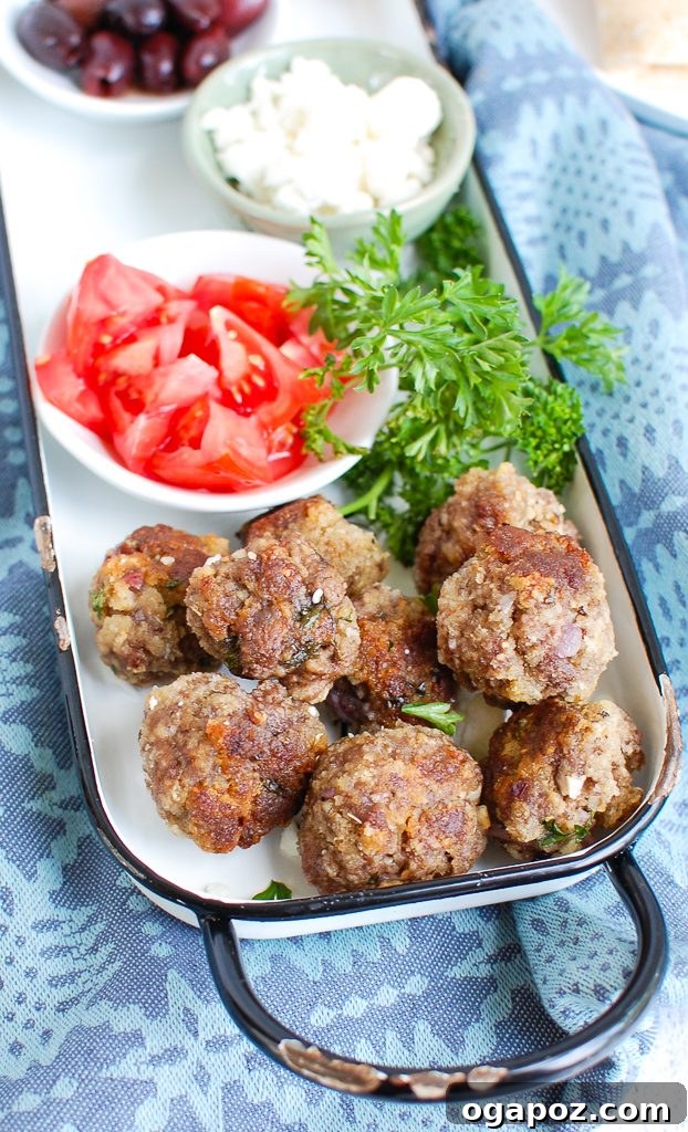 Authentic Greek Keftedes 3 Greek Meatballs arranged neatly on a baking tray before cooking, showing their uniform shape.