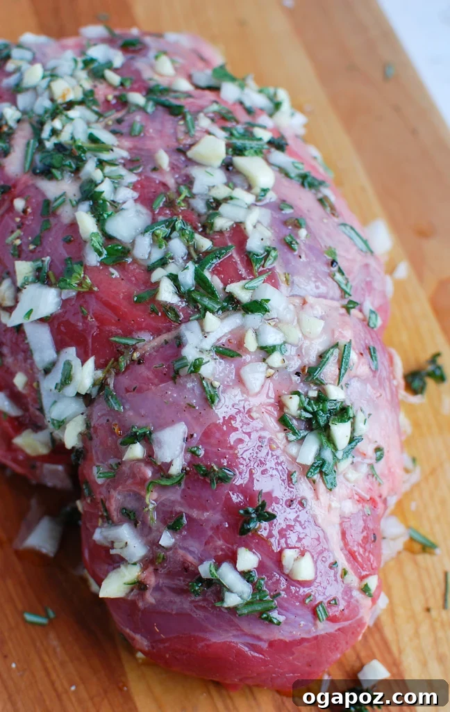 Ultimate Roast Beef Perfection 3 Close-up of fresh rosemary and garlic cloves, ingredients for a savory herb crust on roast beef.