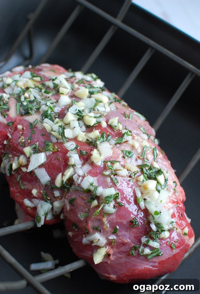 Ultimate Roast Beef Perfection 4 Herb-crusted roast beef cooking in a roasting pan on a wire rack, developing a savory crust.