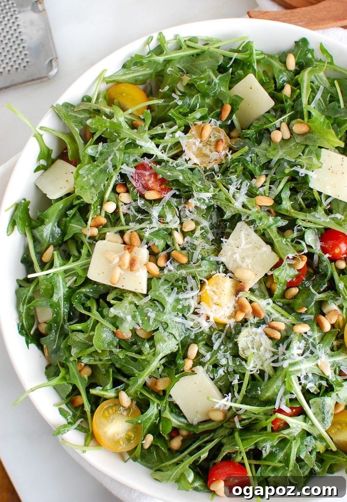 Lemon Arugula Salad with Pine Nuts and Shaved Parmesan Cheese, artfully arranged.